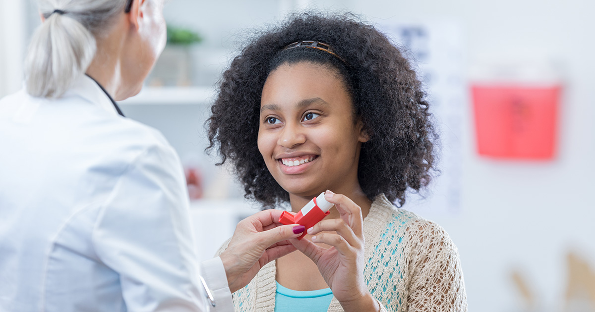 A young woman learning how to use an asthma inhaler