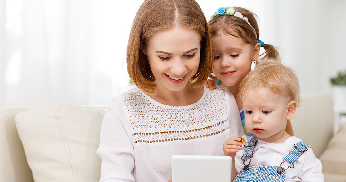 Mom and two babies looking at a tablet