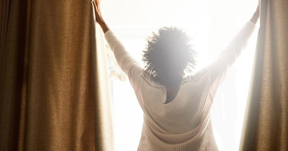 Woman opening drapes