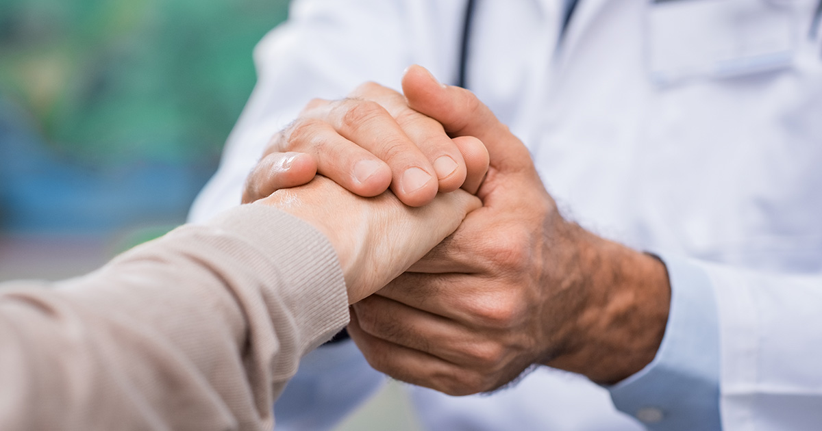 A doctor holding a patient's hand