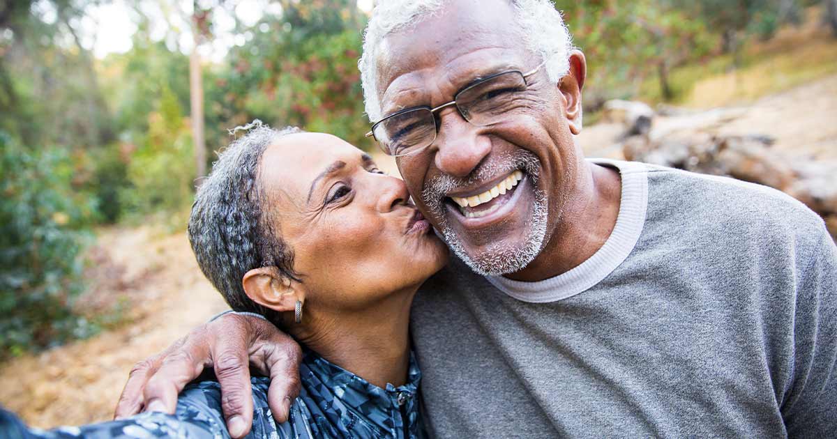 Black senior couple smiling for a kissing selfie