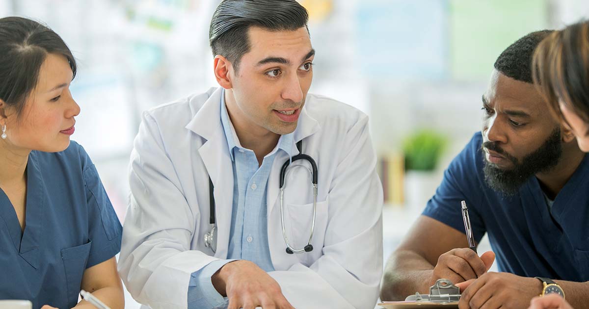 Doctor explaining something to medical professionals