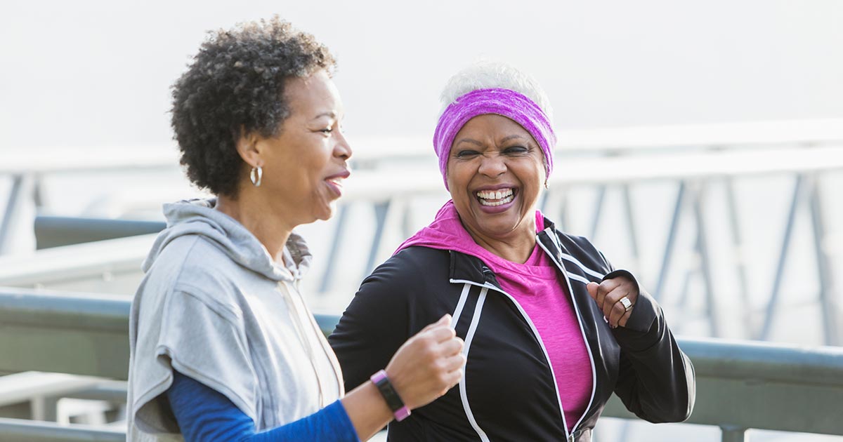 Two senior Black women running outdoors