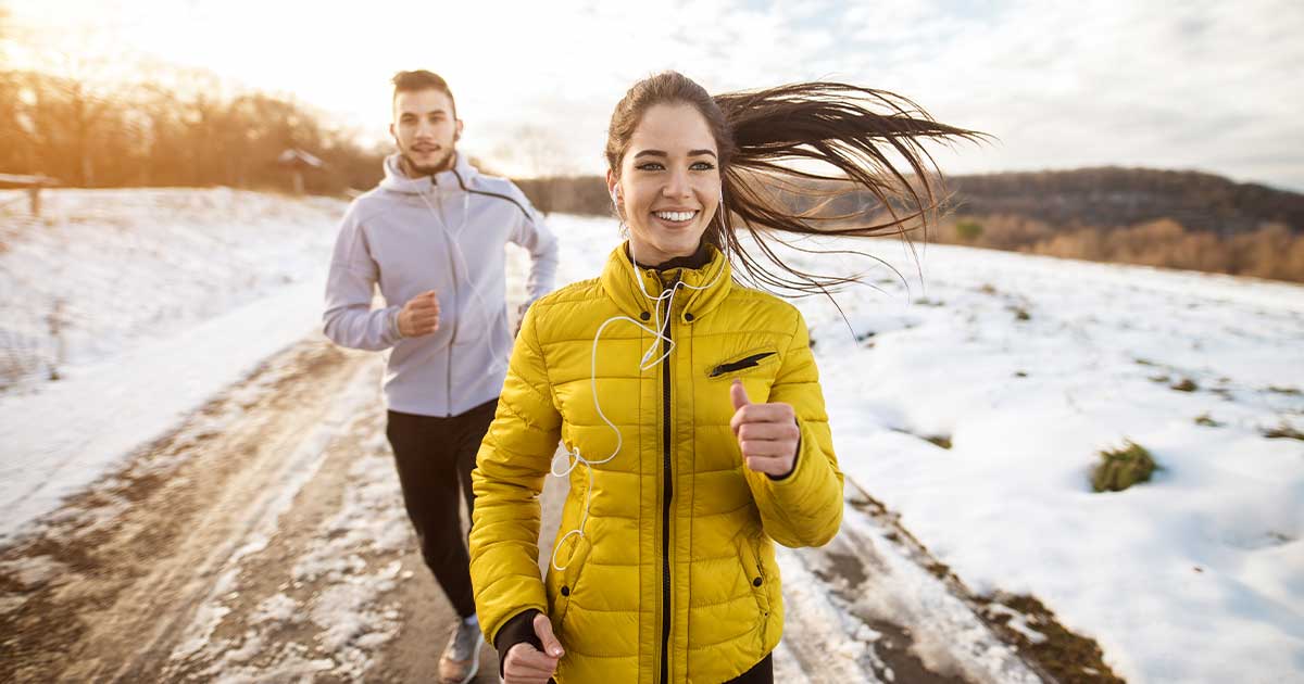 Two people happy to be running outside in the winter