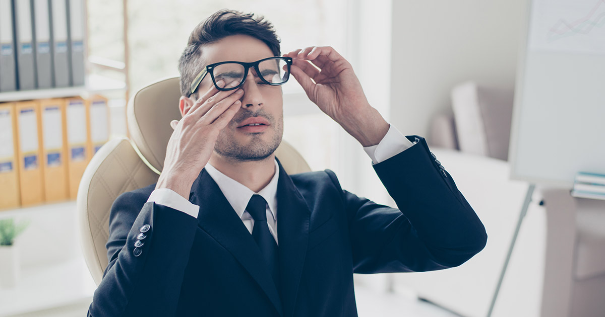 Tired businessman rubbing his eyes