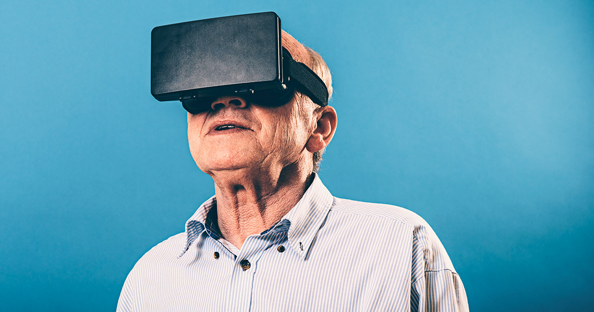 Senior man looking at virtual reality headset