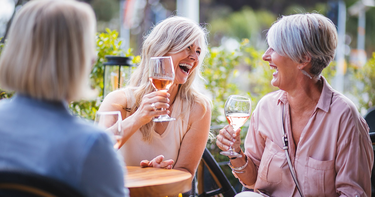 Senior women drinking wine and laughing