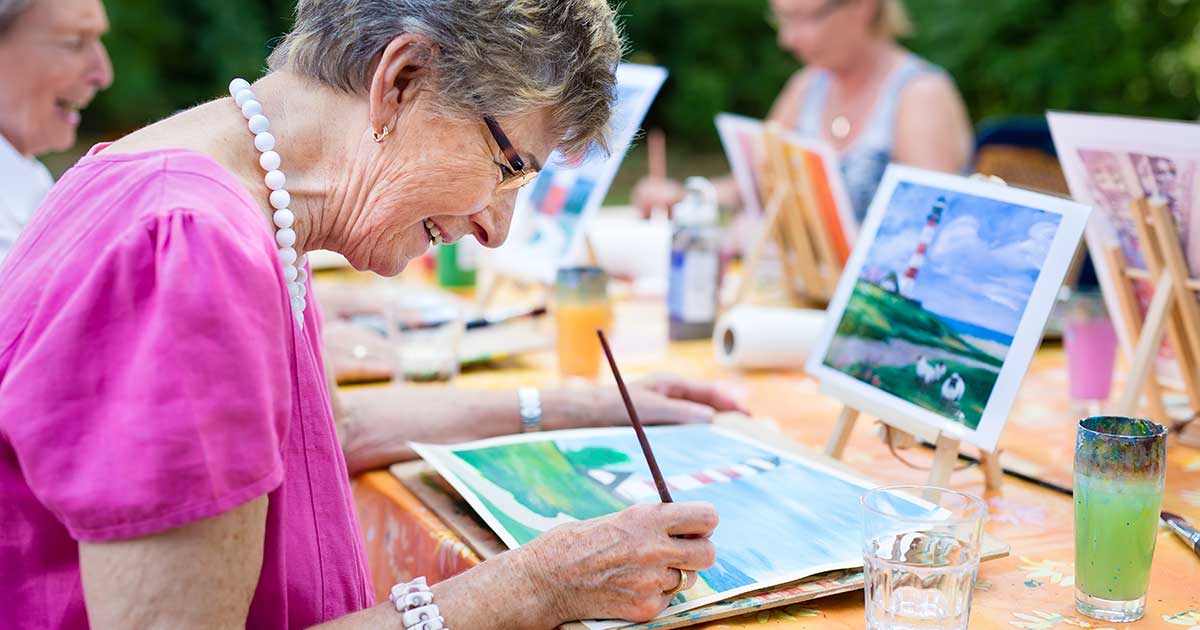 Senior woman happily painting at an event