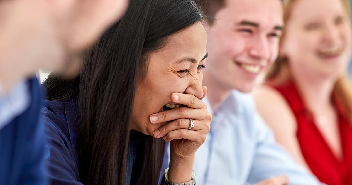Woman laughing into her hand