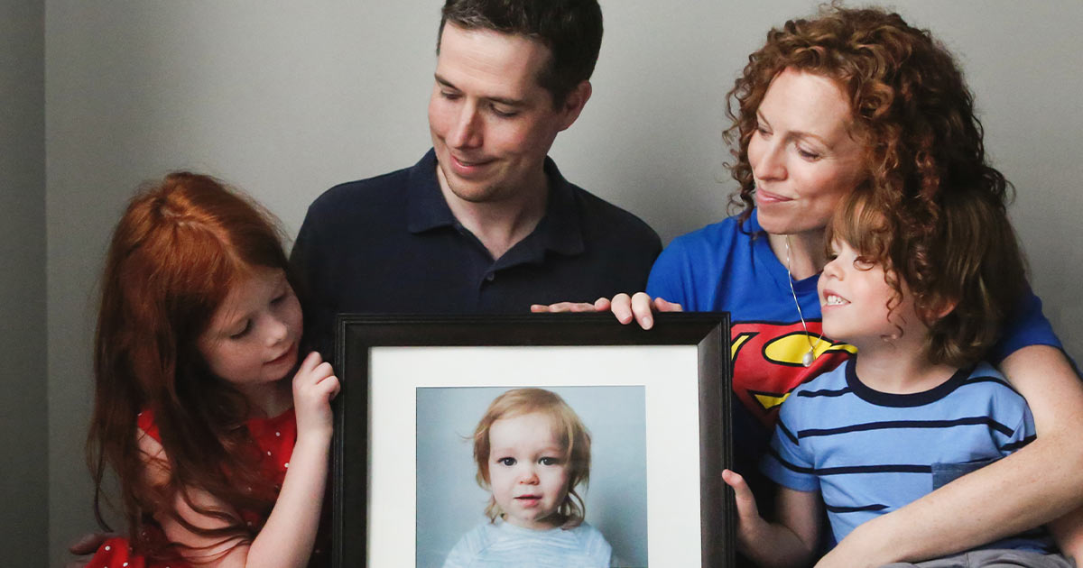 The Promoli family with a framed photograph of Jude