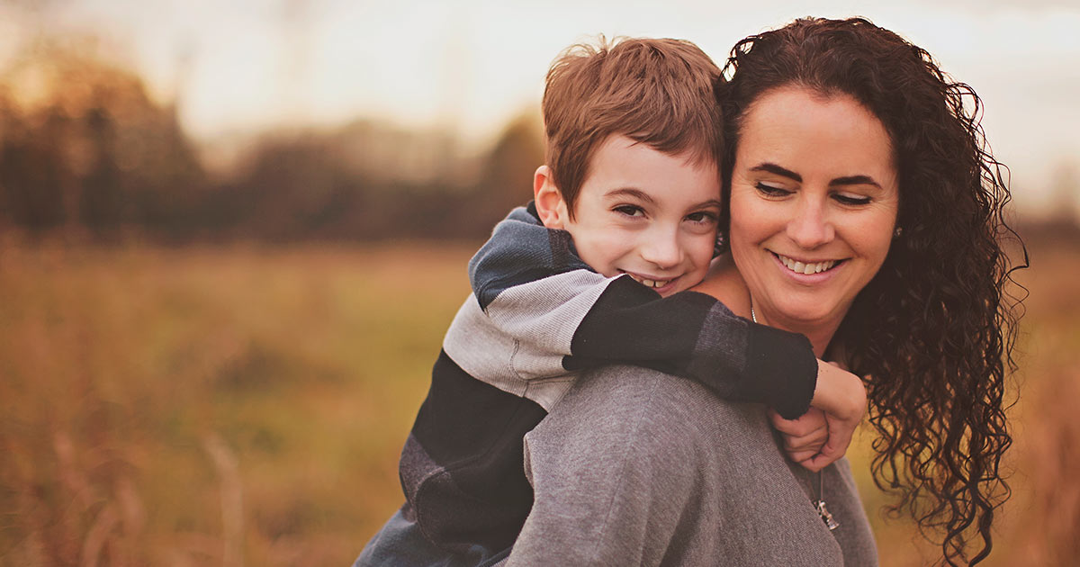 Miles getting a piggyback from his mom, Anne Belanger