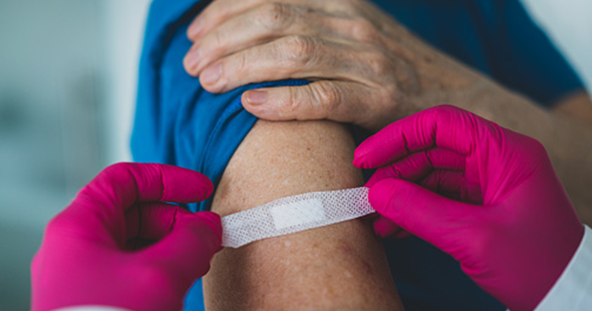 Putting a medical tape on persons arm