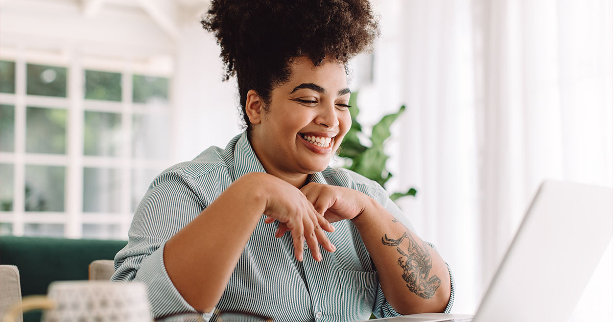 black woman smiling at laptop