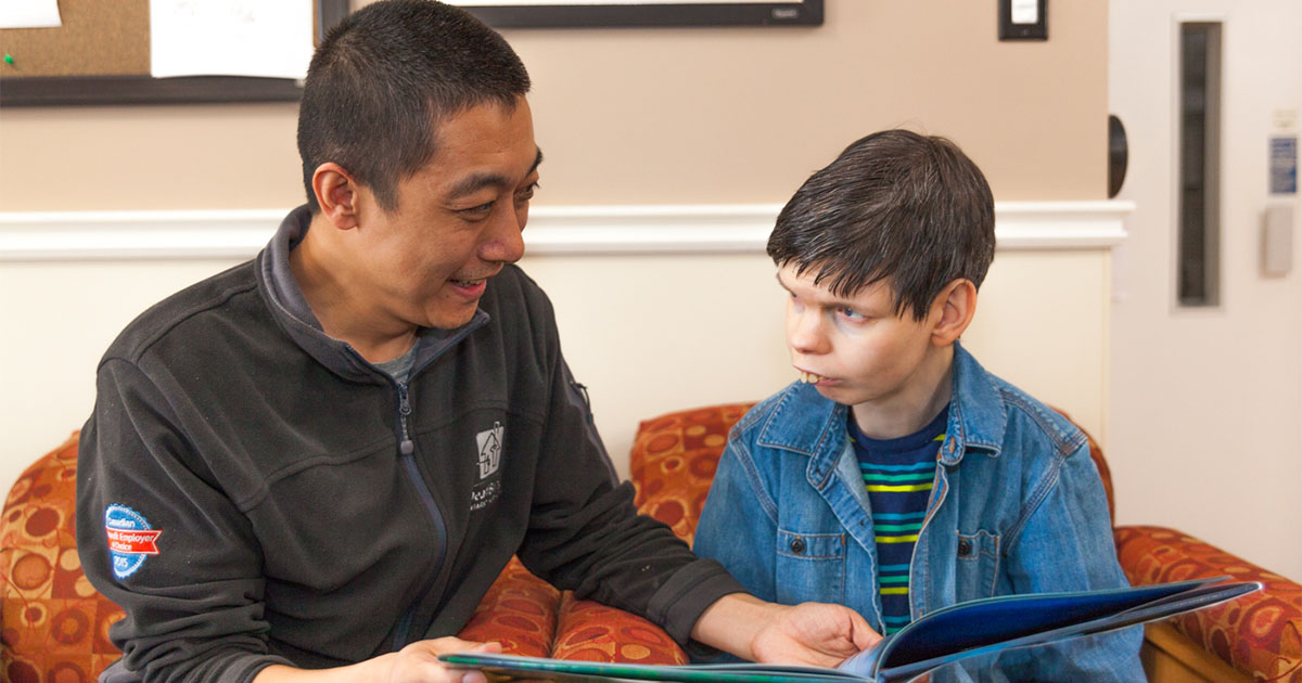 man reading book to disabled child