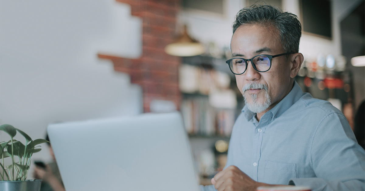 man with glasses looking at computer