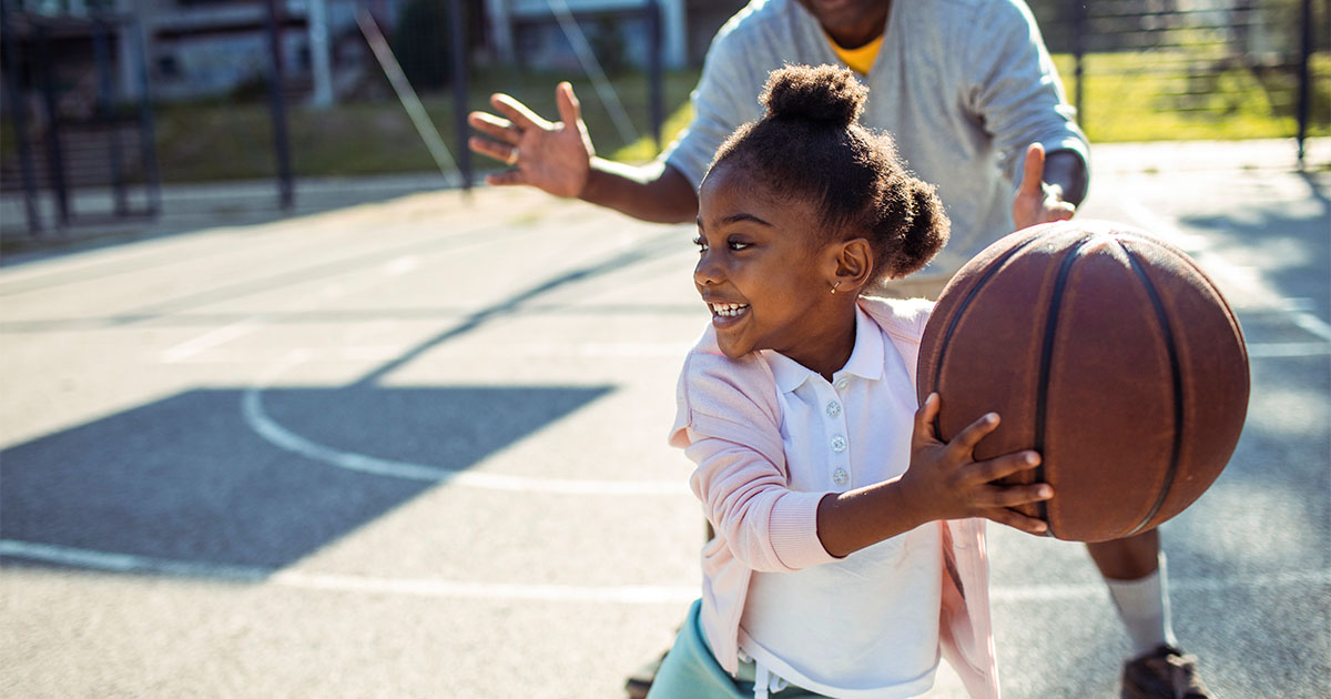 young african american girl playing basketball