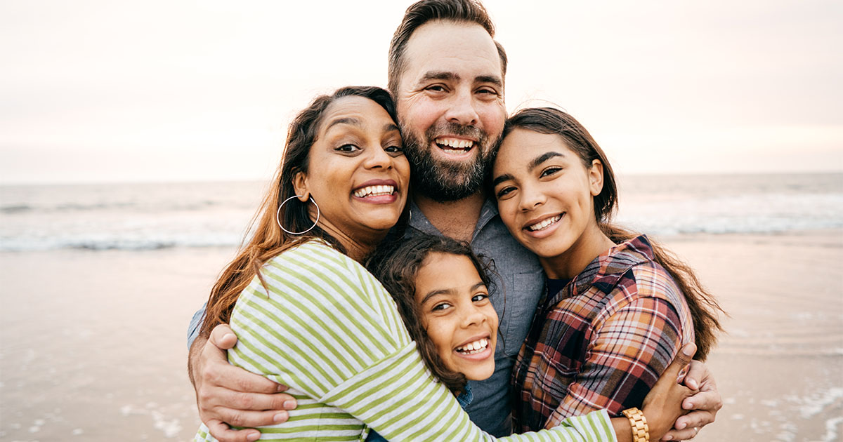 family laughing smiling at beach