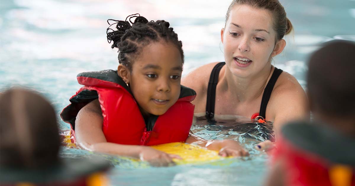 girl getting swimming lessons in pool