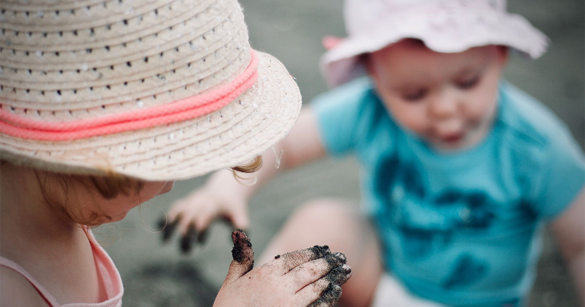 two children sitting on the ground