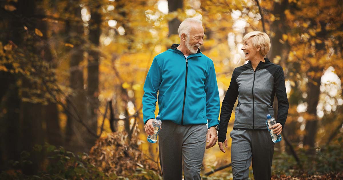 two seniors walking in woods