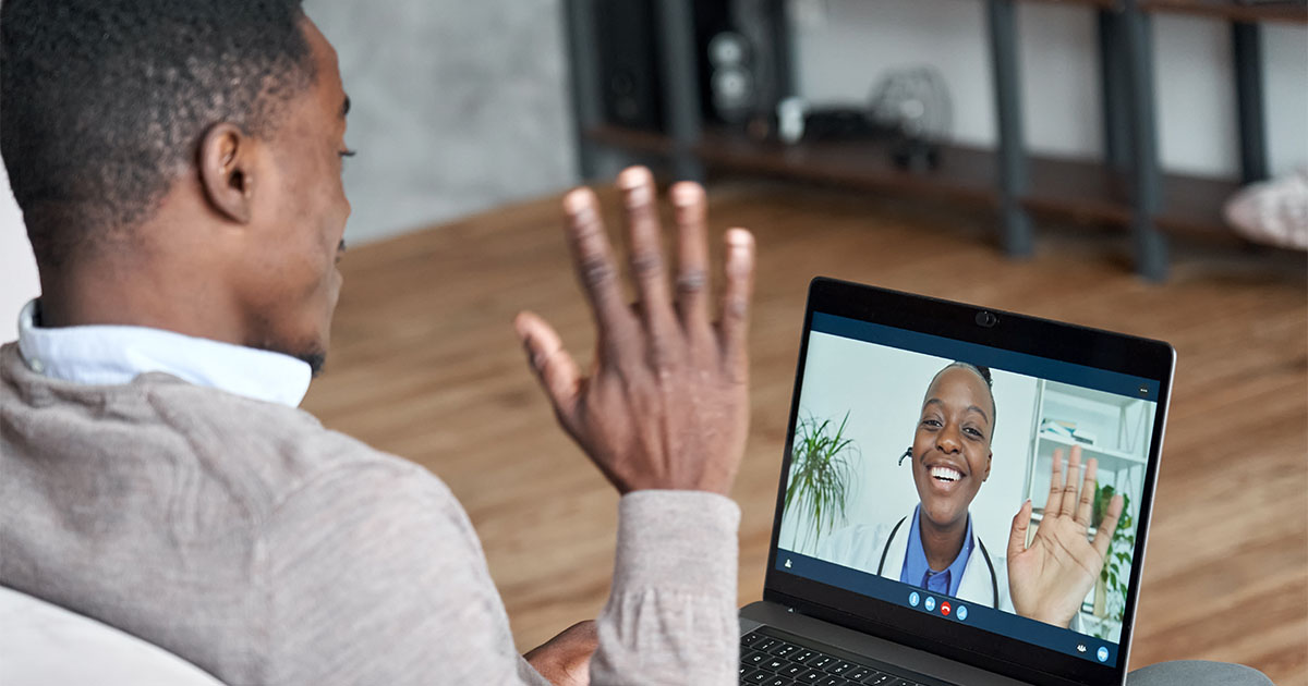 Male black patient talking on video call to female african doctor