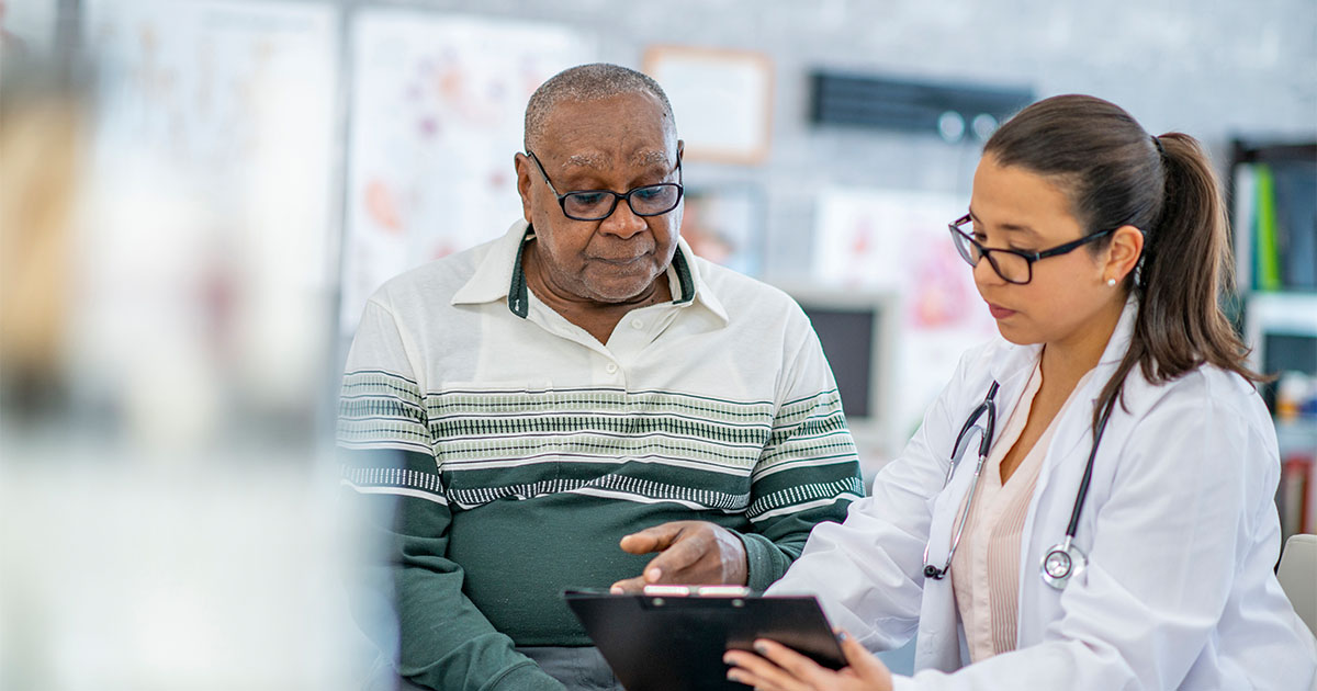 aging african american man with doctor