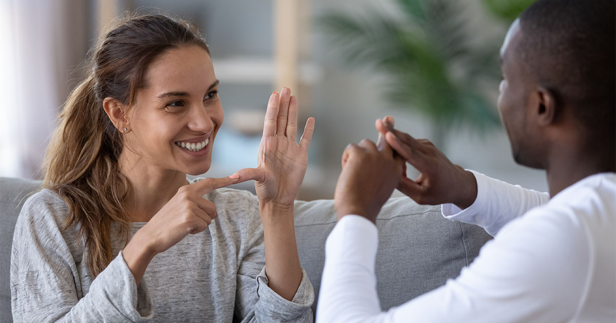 young man and woman using sign language
