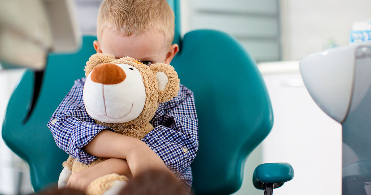 Kid holding onto stuffed bear-Alexion
