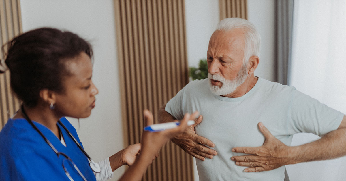 old man clutching his chest at the doctors