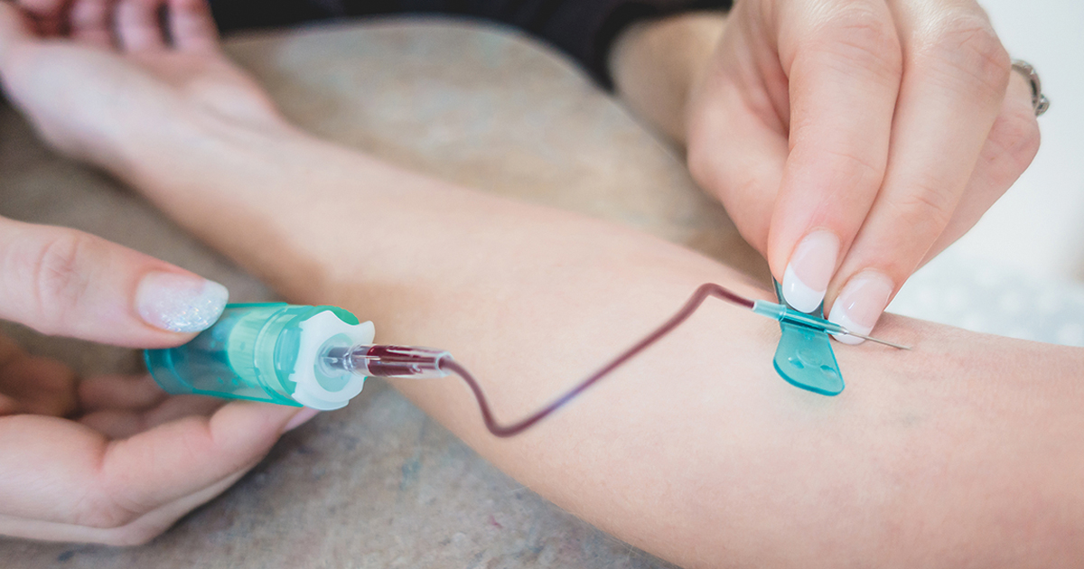 Doctor doing blood work on cancer patient