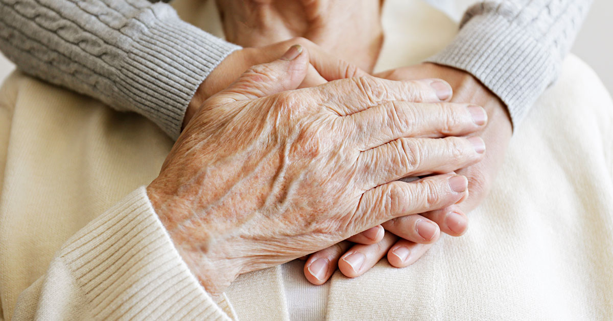Holding hands reassuringly on patients chest