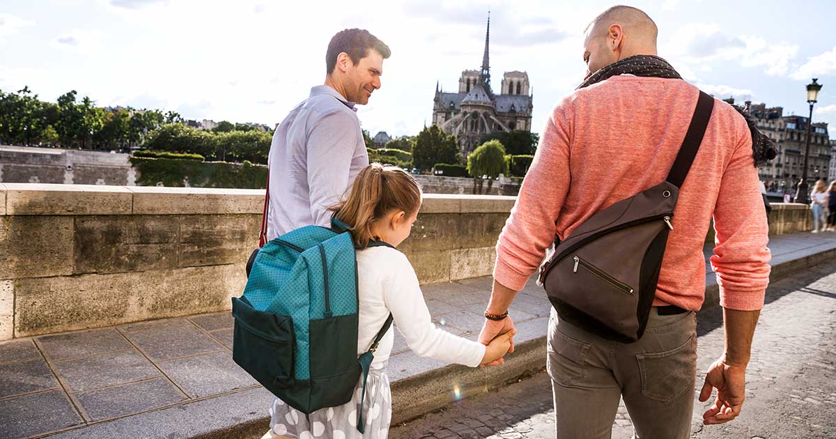 Two dads walking their daughter to school