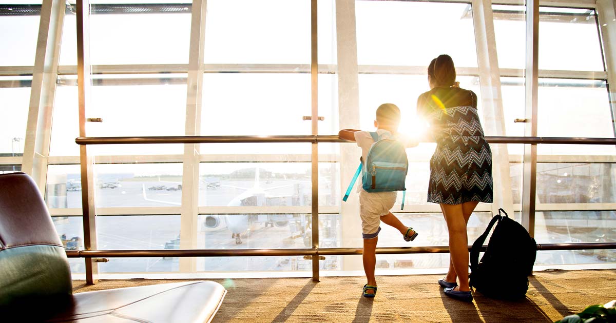 Mother and son looking out of the window in an airport