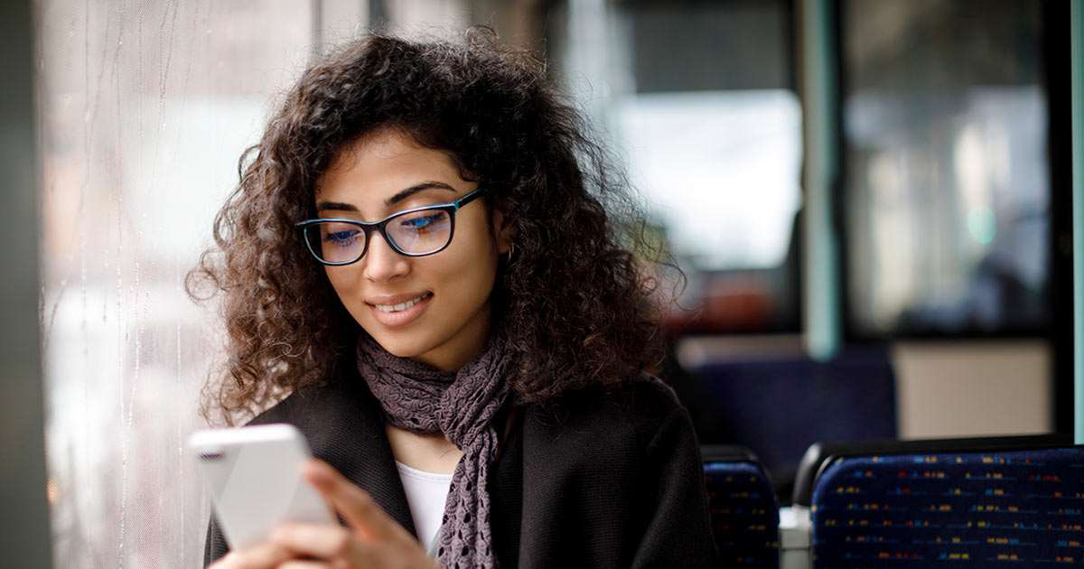 Woman using her mobile phone while sitting on a bus