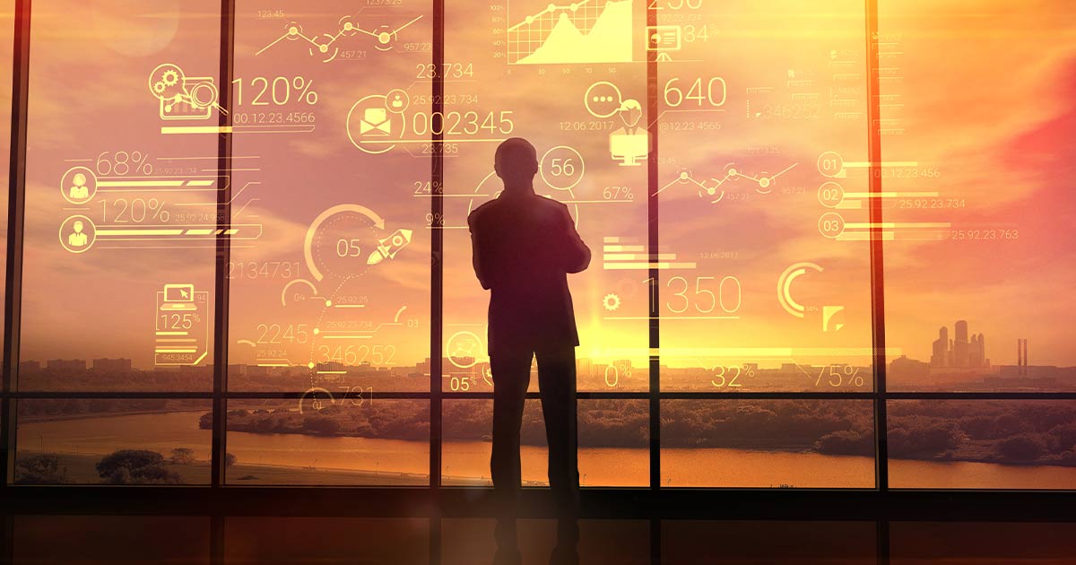 Business man standing in front of sunset