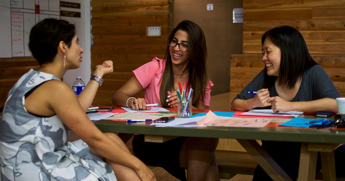 Three women in a meeting, laughing