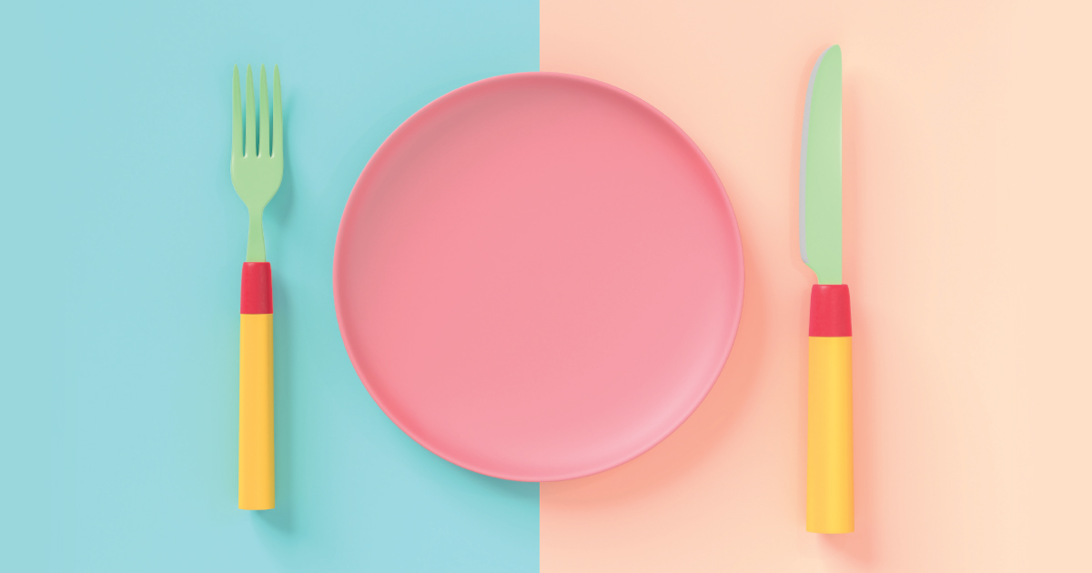 Pastel-coloured fork, plate, and knife laid on a table