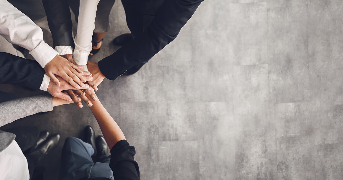 office workers joining hands
