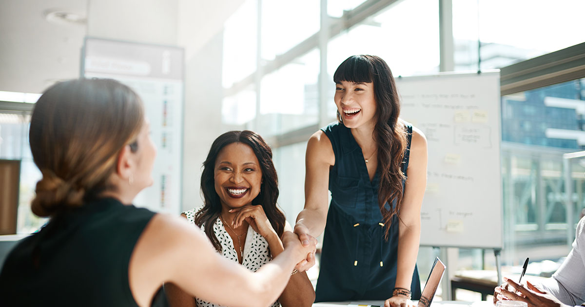 women shaking hands with other women in office