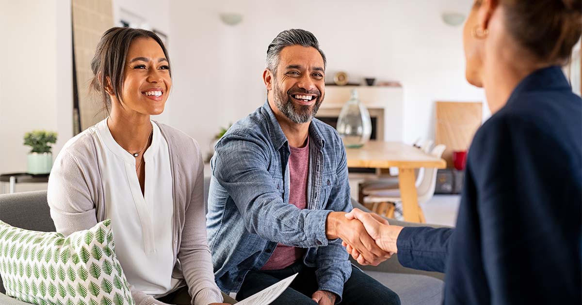 happy couple smiling at insurance broker