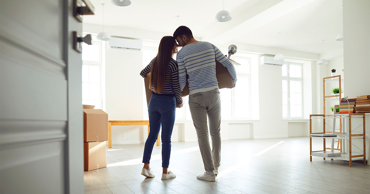 couple holding hands moving into new home