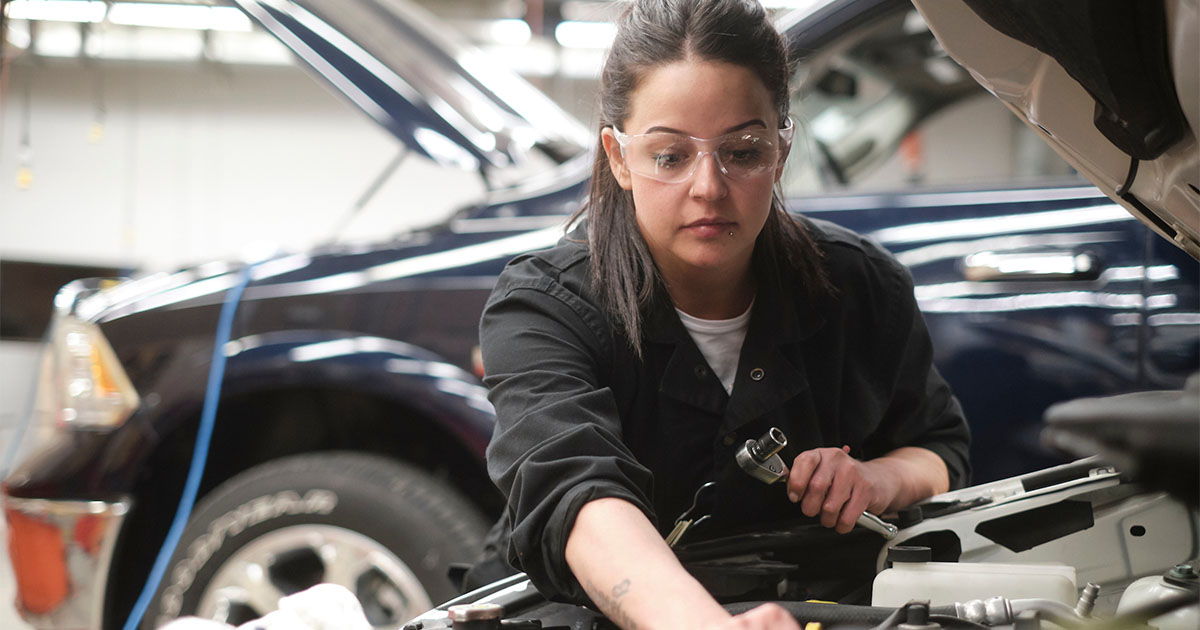 Female mechanic working on car