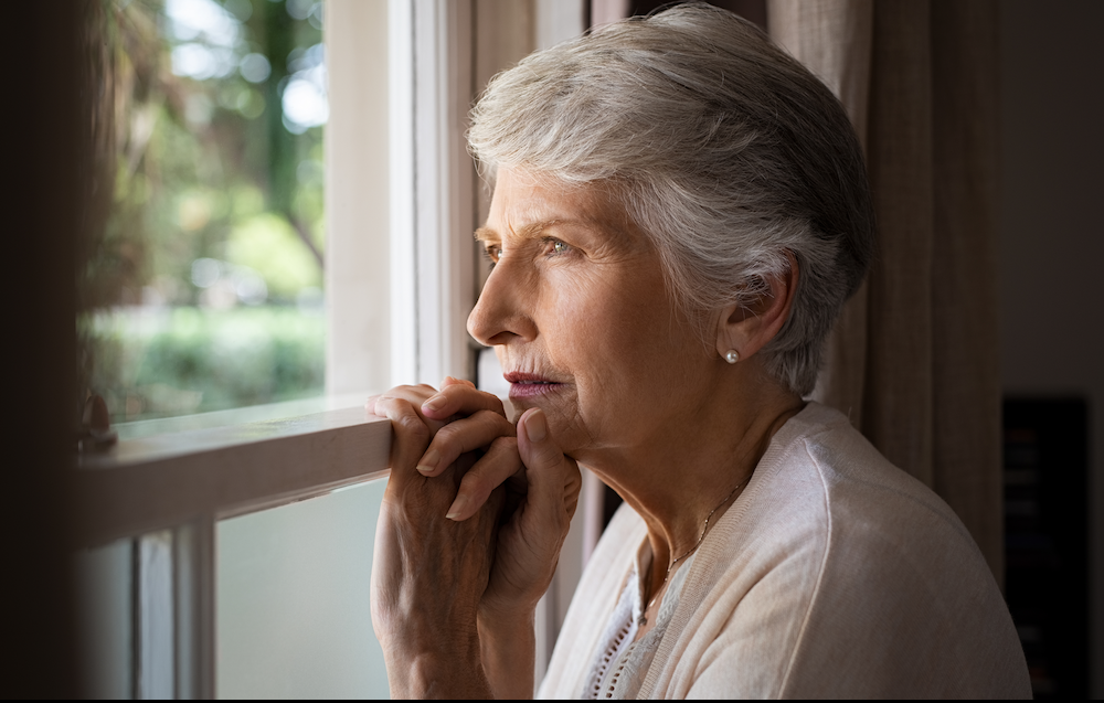 Senior woman looking out the window.