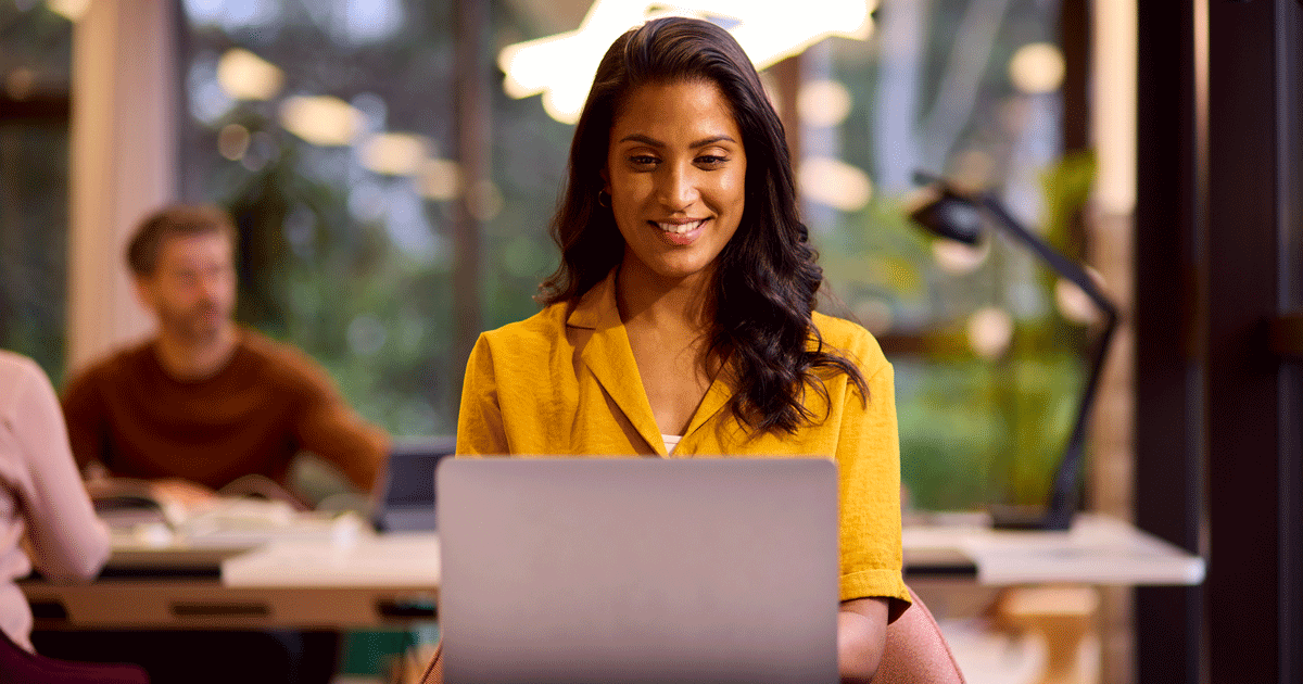 Mature Businesswoman Working On Laptop At Desk In Office