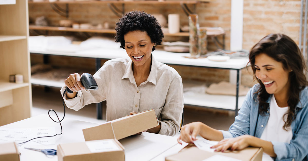 Two online store owners preparing orders for shipping in their warehouse