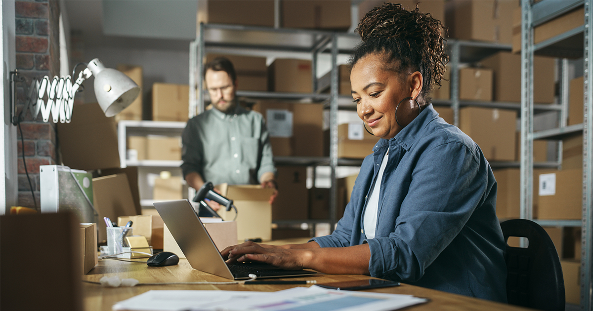Diverse Male and Female Warehouse Inventory Managers Talking, Using Laptop Computer and Checking Retail Stock