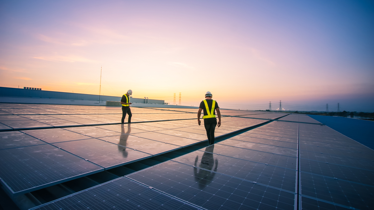 Engineer service check installation solar cell on the roof of factory on the morning.