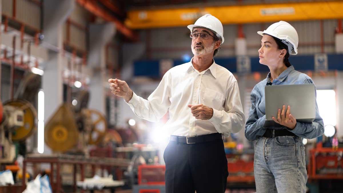 two professional engineer,worker,technician use clipboard discuss work, walk in steel metal manufacture factory plant industry