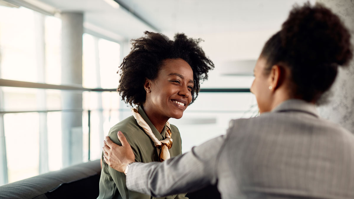 Happy African American business apprentice having meeting with her mentor in the office