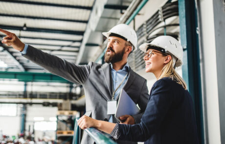 A portrait of an industrial man and woman engineer with tablet in a factory, working